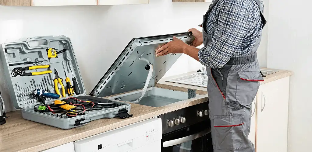Handyman repairing a cooktop and checking wiring connections in Sioux Falls, SD