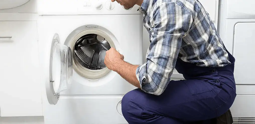 Handyman inspecting a dryer drum and internal parts for repair in Sioux Falls, SD