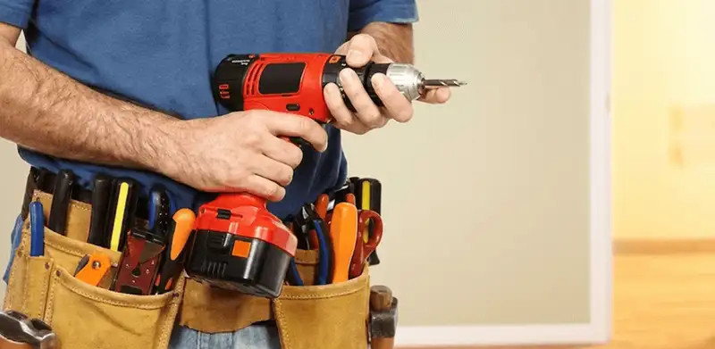 Handyman holding a power drill for home repairs and installations in Sioux Falls, SD